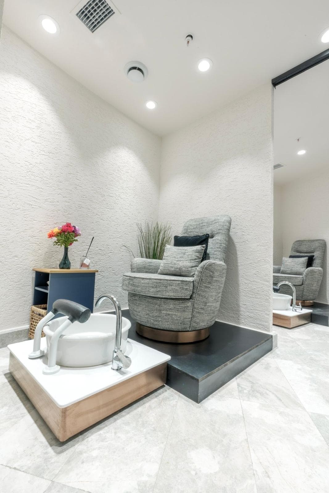 Spa bölümü: pedikür ünitesi ve tekli koltuğuyla beyaz bakım odası